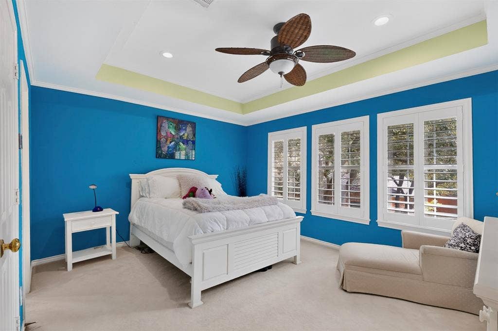 4536 Briar Oaks Circle, Dallas, TX 75287 Three windows with plantation shutters, recessed lighting, ceiling fan, crown molding, and tray ceiling