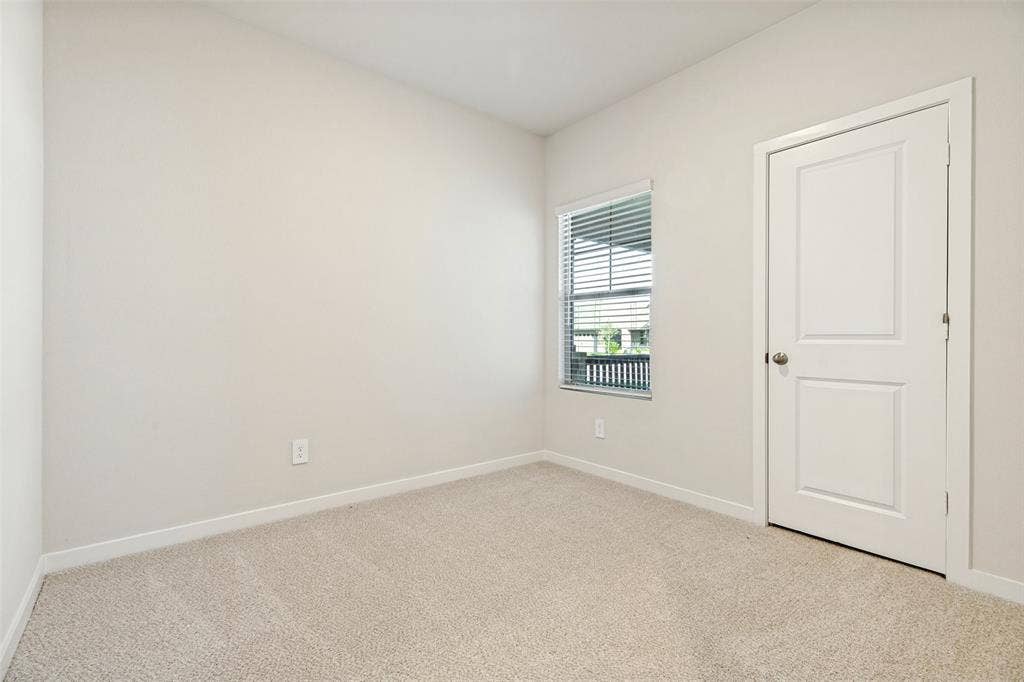 1006 Angel Street, Josephine, TX 75173 A Flexible Space to Make Your Own! - This bright secondary bedroom features neutral carpeting, crisp white walls, and a window overlooking the covered front porch. An inviting space with possibilities for a guest room, home office, or creative retreat.