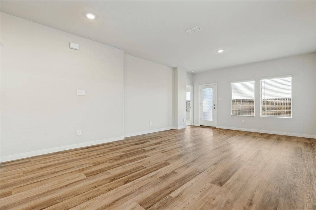 1006 Angel Street, Josephine, TX 75173 Open, Airy & Designed for Everyday Living! - The spacious family room features durable executive vinyl plank flooring, recessed lighting, and an open layout that connects effortlessly with the dining area and kitchen, making everyday living and entertaining a breeze.