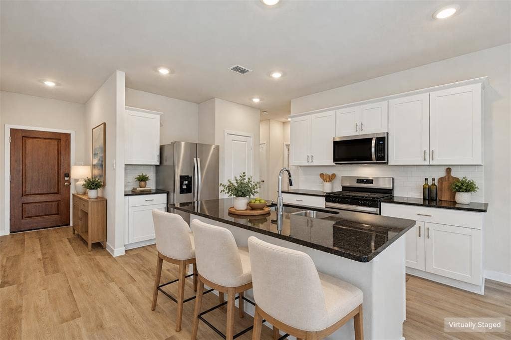 1006 Angel Street, Josephine, TX 75173 A Kitchen Designed for Real Life! - Enjoy generous counter space, abundant cabinet storage, and a central island with an undermount sink and breakfast bar. The stainless steel gas range, built-in microwave, and refrigerator make this thoughtfully arranged kitchen ready for everyday cooking and entertaining.