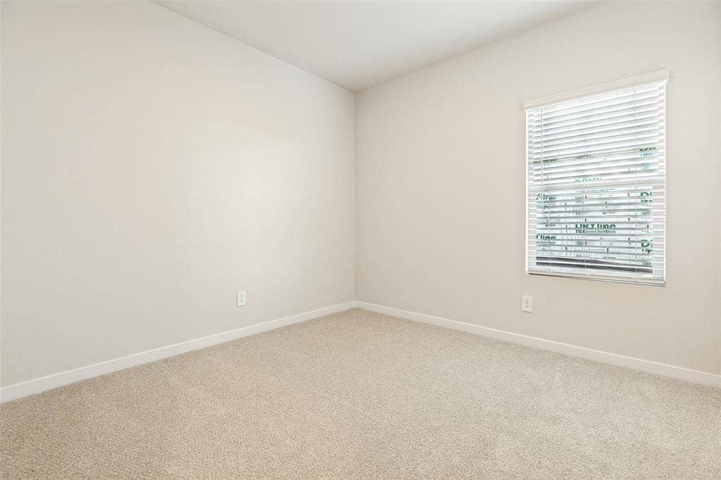 1006 Angel Street, Josephine, TX 75173 Comfortable, Bright & Move-In Ready! - This secondary bedroom offers soft carpeting, fresh neutral finishes, and natural light through a window with included blinds. A clean, versatile space ready to accommodate your personal style.
