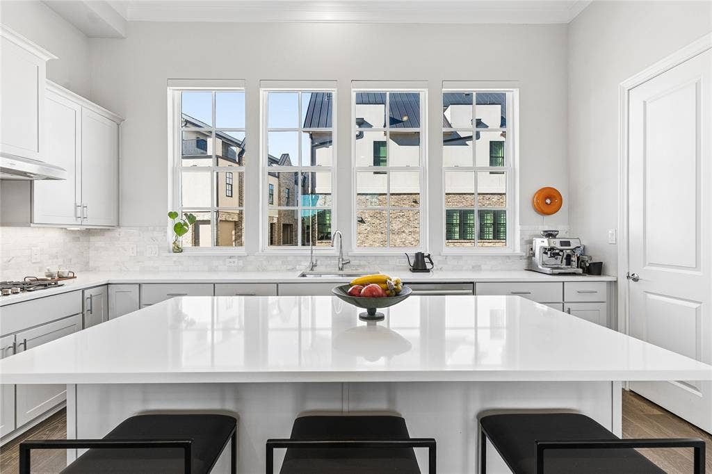 Kitchen features abundant natural light with a warm neutral color pallette.