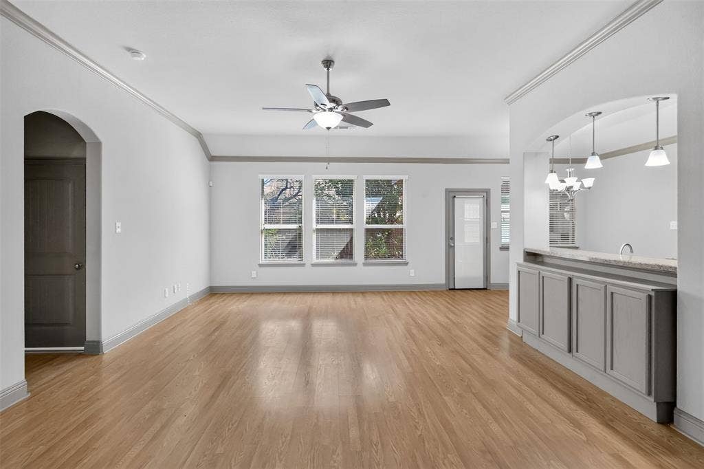 LIVING ROOM WITH CROWN MOLDING AND FAN