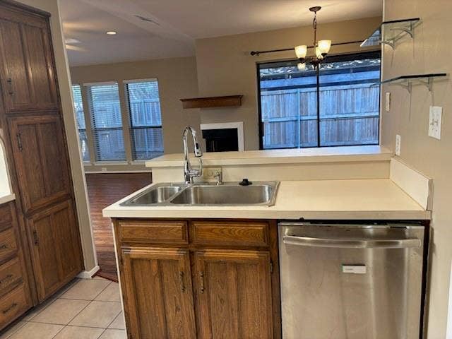 3028 Airhaven Street, Dallas, TX 75229 Kitchen featuring wood cabinetry, stainless steel dishwasher, dual basin sink with a gooseneck faucet, light-toned countertops, and tile flooring