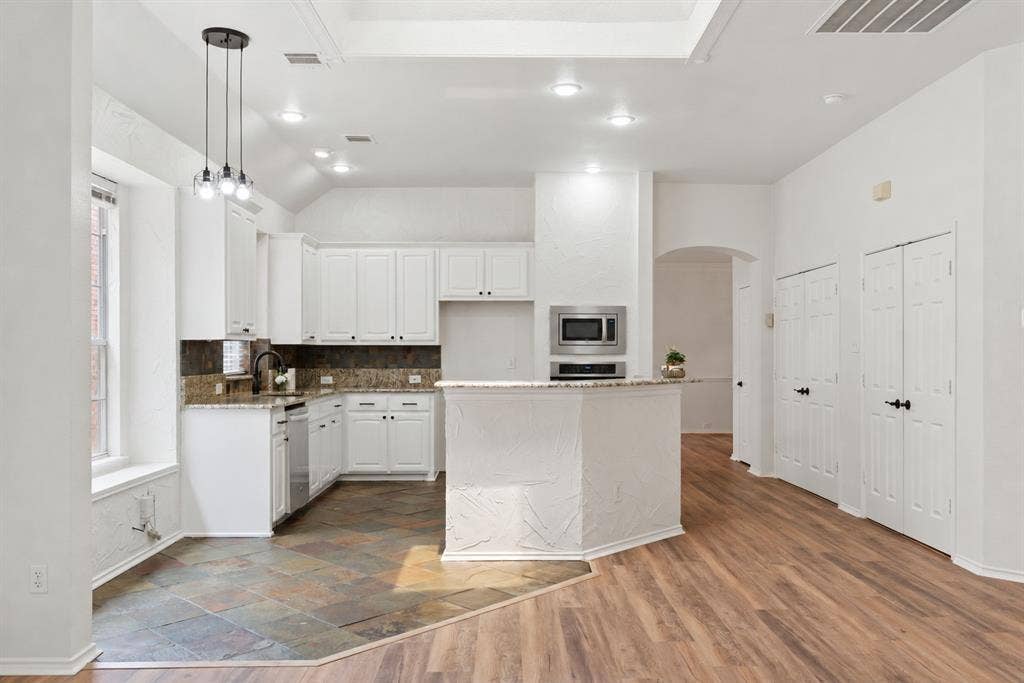4816 Rockcreek Lane, Plano, TX 75024 Kitchen featuring white cabinetry, stainless steel appliances, granite countertops, and stone tile flooring