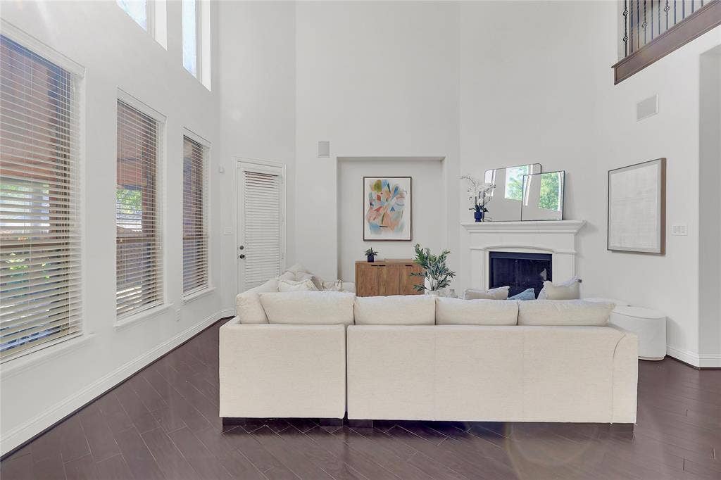 8730 Isaac Street, Plano, TX 75024 Living area with a towering ceiling, a fireplace, and dark wood-style floors