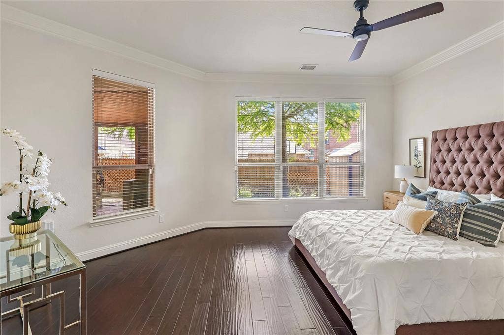 8730 Isaac Street, Plano, TX 75024 Bedroom with multiple windows, dark wood finished floors, crown molding, and ceiling fan