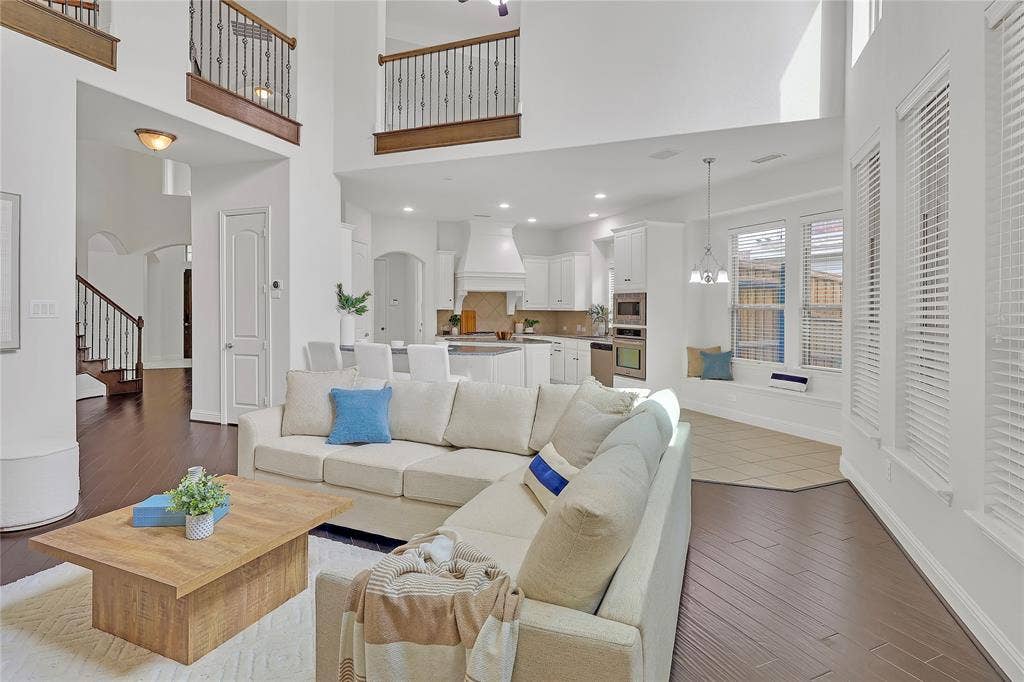 8730 Isaac Street, Plano, TX 75024 Living area with arched walkways, a high ceiling, wood finished floors, and stairs