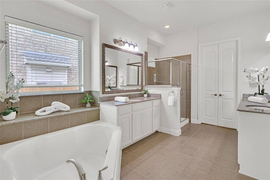 8730 Isaac Street, Plano, TX 75024 Bathroom featuring vanity, a garden tub, a shower stall, and tile patterned floors