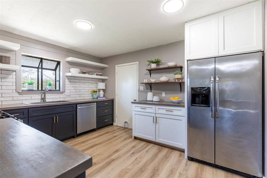 Fully remodeled kitchen with white and black cabinetry.
