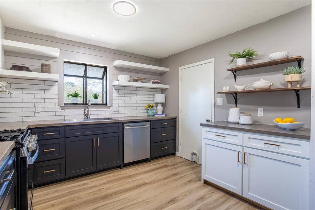 Kitchen features cabinetry and modern open shelving.