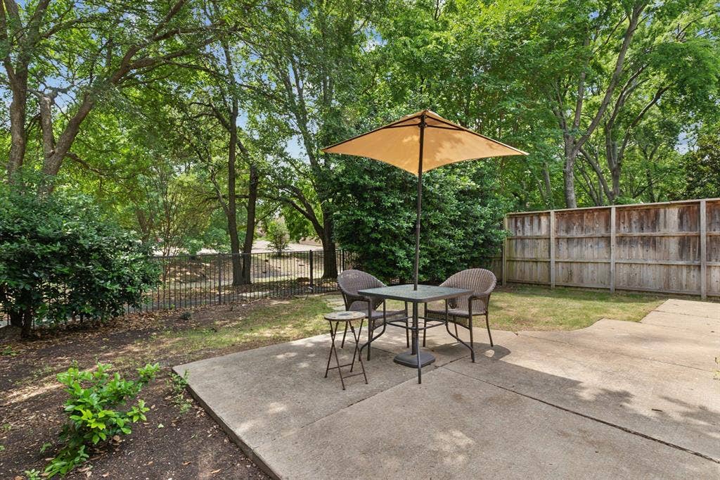 4816 Rockcreek Lane, Plano, TX 75024 Concrete patio with an expansive fenced yard, mature trees, and privacy hedges
