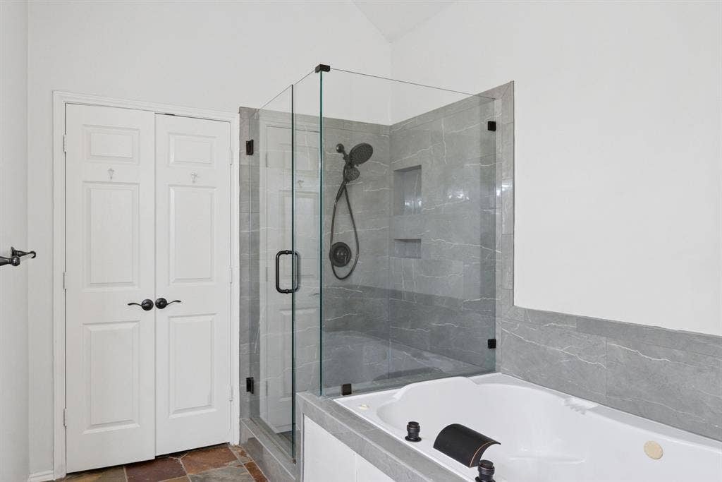 4816 Rockcreek Lane, Plano, TX 75024 Glass-enclosed shower with gray tiled walls and a built-in niche
