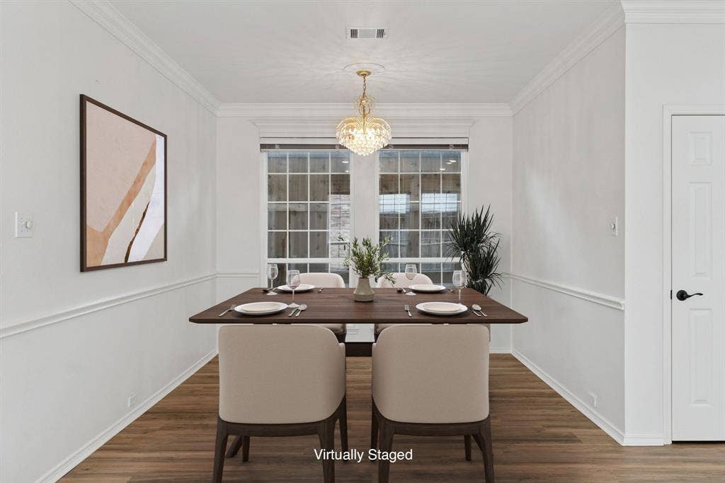 4816 Rockcreek Lane, Plano, TX 75024 Wood-finish flooring, white walls with decorative molding, and a crystal chandelier