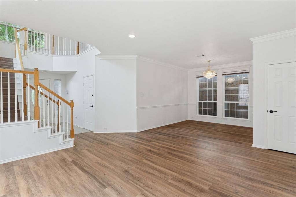 4816 Rockcreek Lane, Plano, TX 75024 Wood-finish flooring throughout, with a grand staircase featuring white spindles and wood handrails