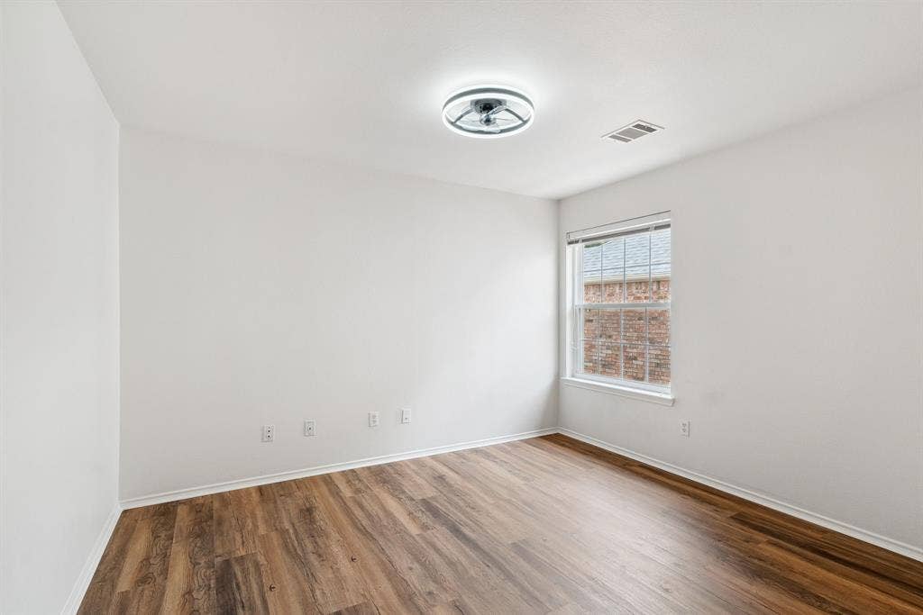 4816 Rockcreek Lane, Plano, TX 75024 Wood-finish flooring with white baseboards, single window, and flush mount lighting
