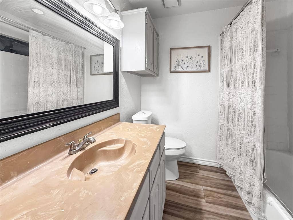 316 N Winding Oaks Drive, Wylie, TX 75098 Bathroom featuring a vanity with an integrated sink, wood-finish flooring, and a built-in cabinet