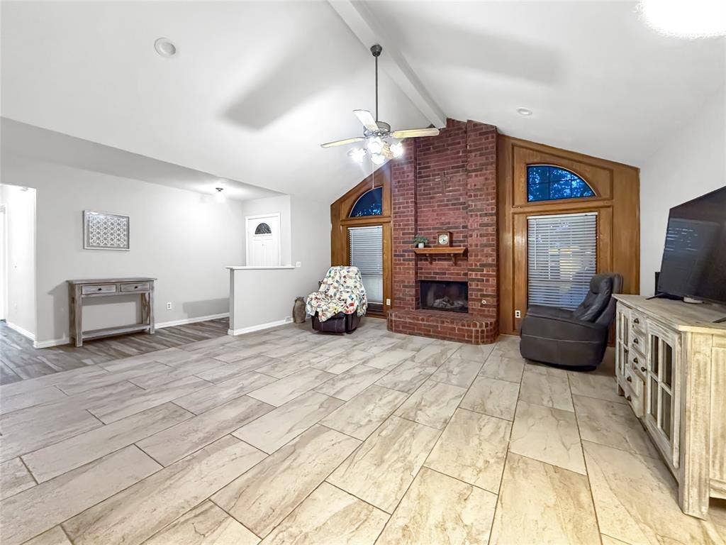 316 N Winding Oaks Drive, Wylie, TX 75098 Spacious living area featuring vaulted ceilings, a brick fireplace, and wood-finish flooring