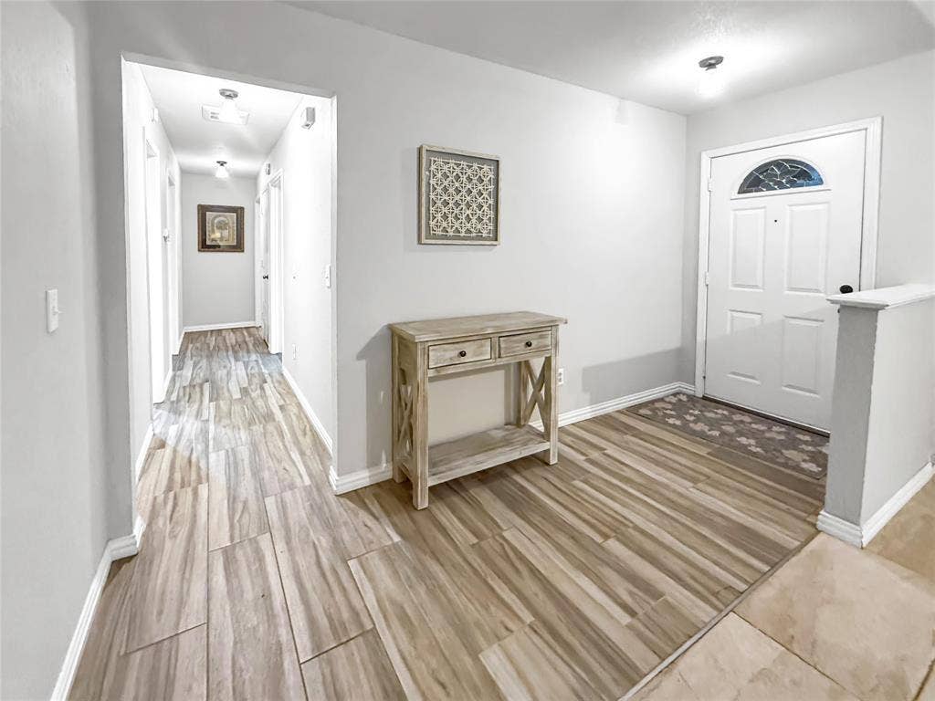 316 N Winding Oaks Drive, Wylie, TX 75098 Wood-finish flooring throughout, bright white entry door with decorative glass, and a neutral wall color