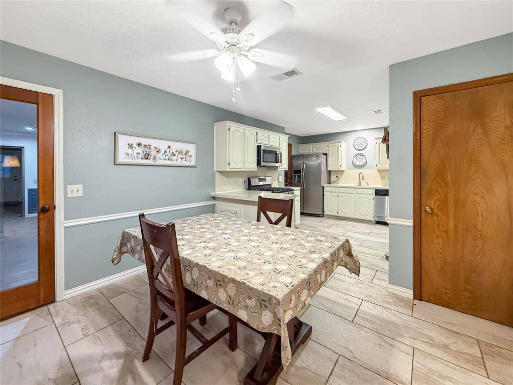 316 N Winding Oaks Drive, Wylie, TX 75098 Kitchen featuring light-colored cabinetry, stainless steel appliances, and a ceiling fan