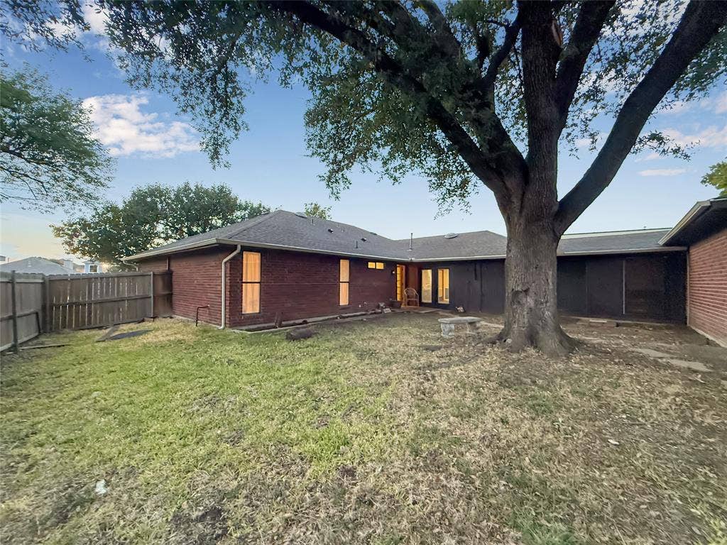 316 N Winding Oaks Drive, Wylie, TX 75098 Expansive backyard featuring a mature tree, brick exterior, and a privacy fence