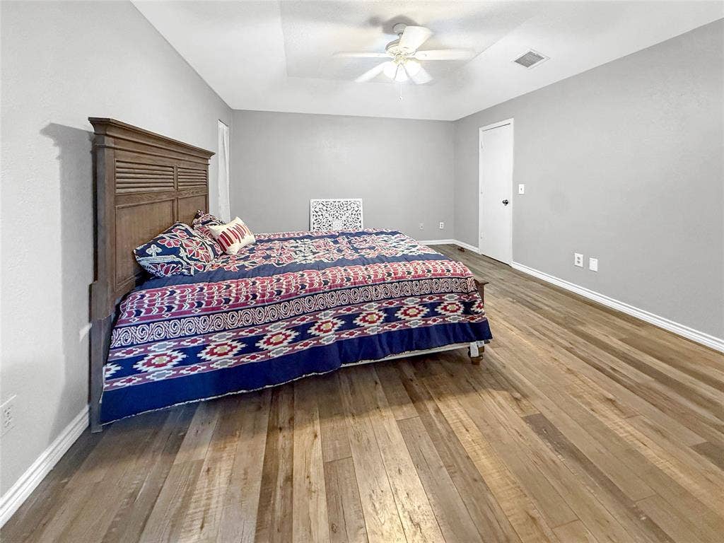 316 N Winding Oaks Drive, Wylie, TX 75098 Wood-finish flooring, light gray wall paint, white trim, and a white ceiling fan with light fixture