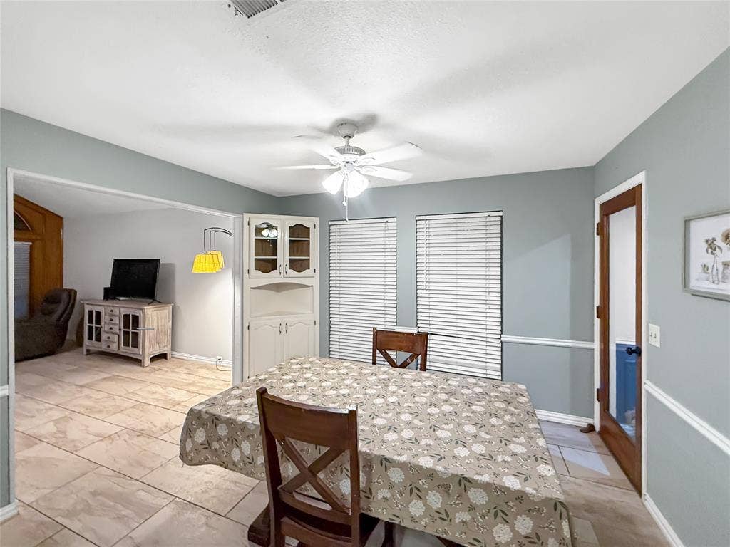 316 N Winding Oaks Drive, Wylie, TX 75098 Tile flooring throughout, white ceiling fan with integrated lighting, built-in display cabinetry, and multiple windows with blinds