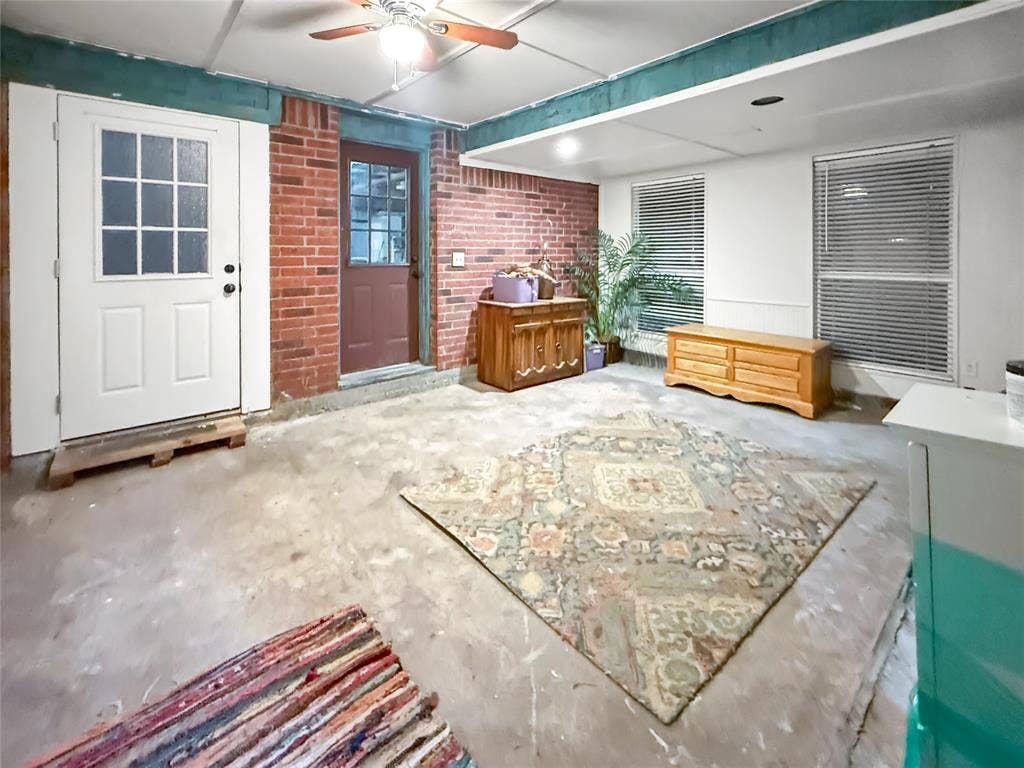 316 N Winding Oaks Drive, Wylie, TX 75098 Covered patio featuring a ceiling fan, exposed brick wall, and two external doors