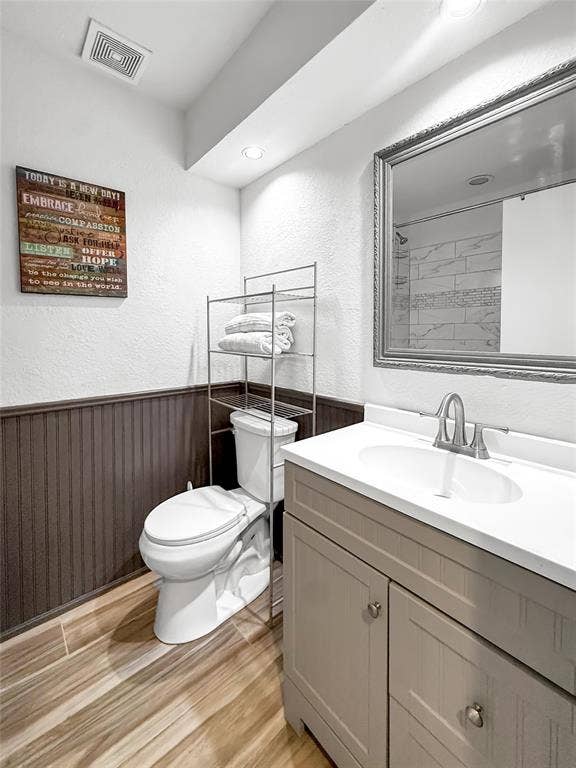 316 N Winding Oaks Drive, Wylie, TX 75098 White single-basin vanity with a light countertop, wood-finish flooring, and dark wainscoting