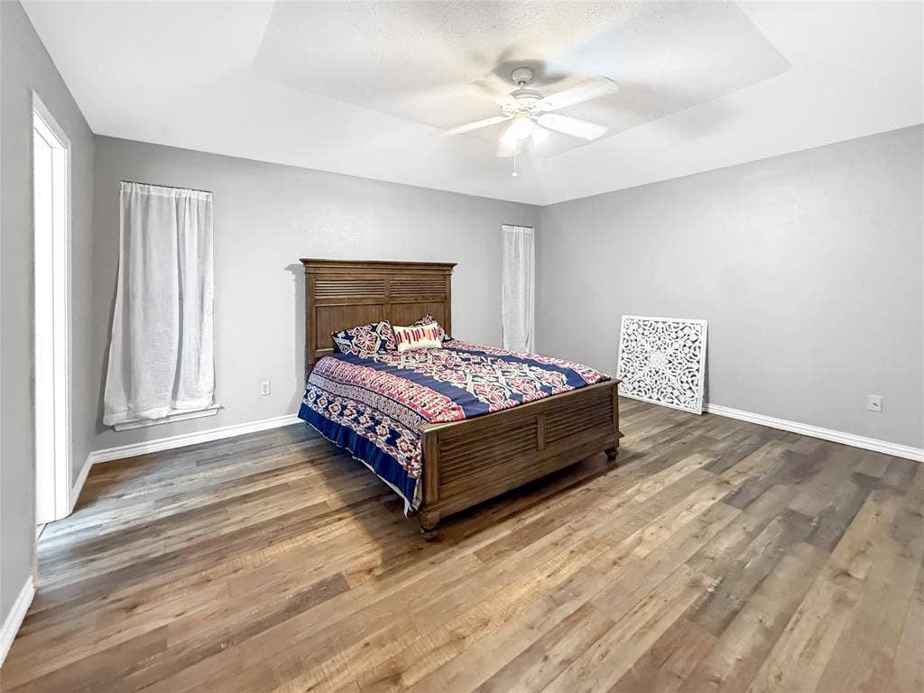 316 N Winding Oaks Drive, Wylie, TX 75098 Tray ceiling with a ceiling fan, wood-finish flooring, and light gray walls