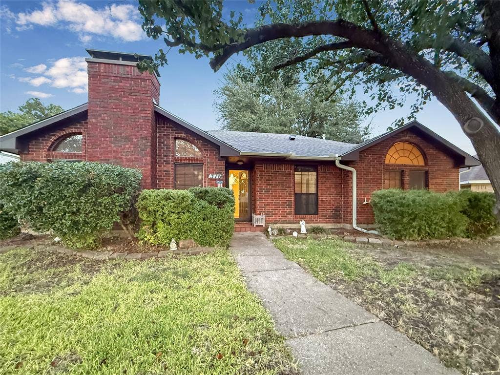 316 N Winding Oaks Drive, Wylie, TX 75098 Red brick exterior with a prominent brick chimney, arched windows, and a mature tree providing natural shade