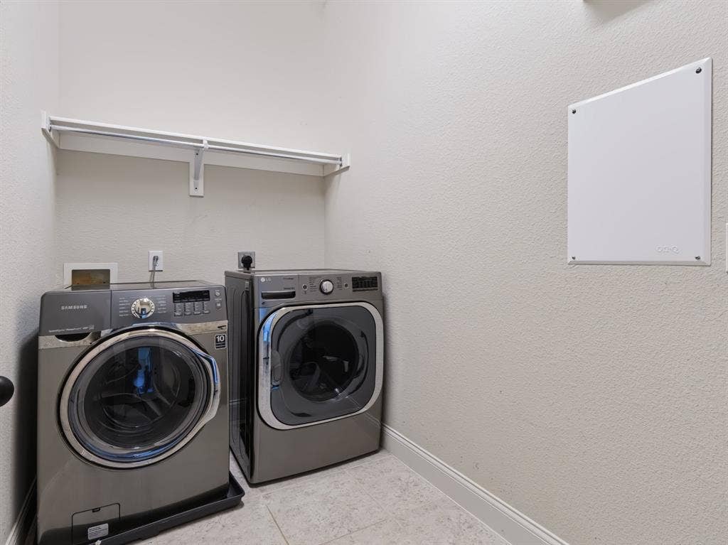 Laundry area featuring a tiled floor and an integrated wall shelf