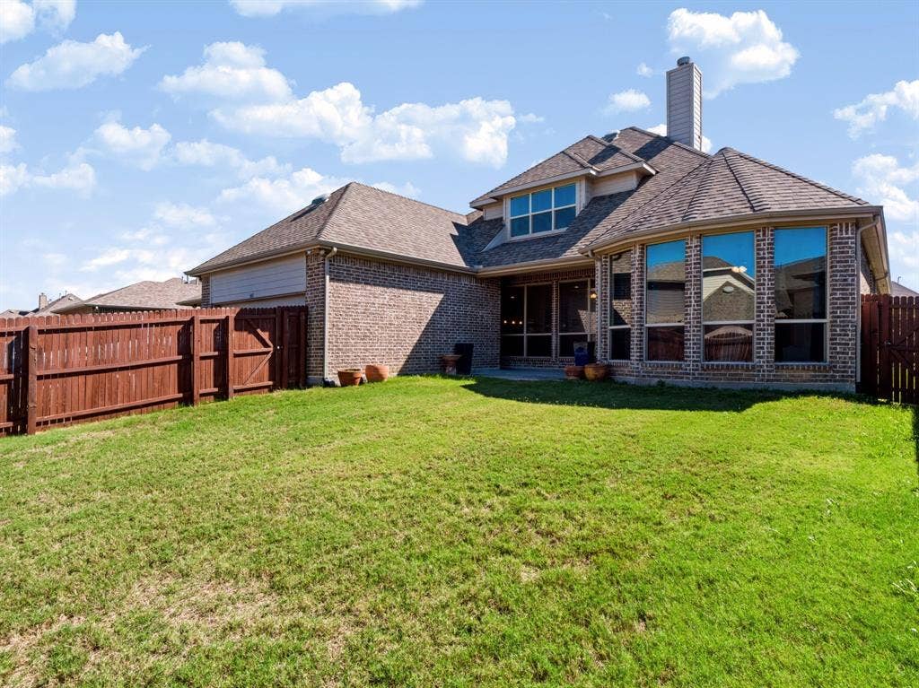 Expansive green lawn with a privacy fence