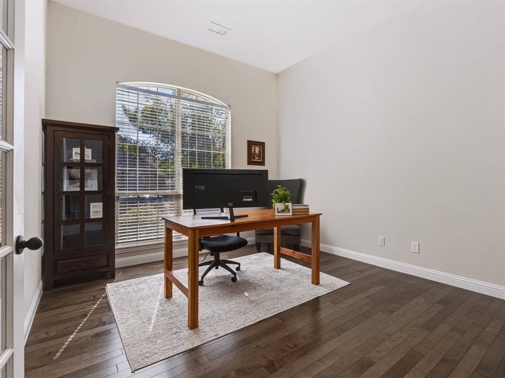 Vaulted ceiling, arched window with horizontal blinds, French doors, dark wood-finish flooring, and light wall finishes