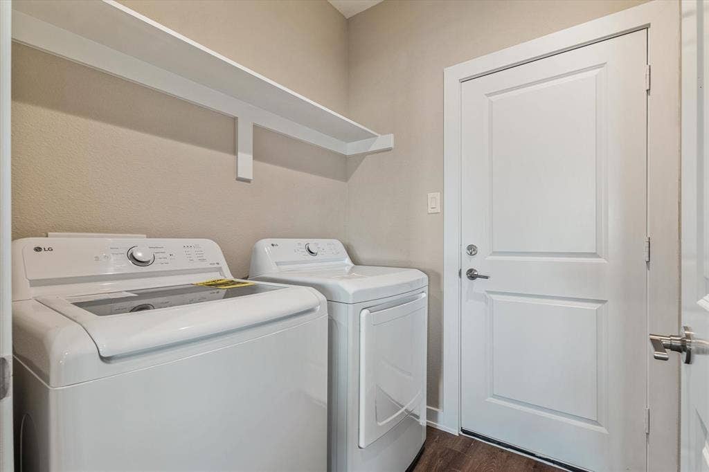 Laundry area with built-in shelving and wood-finish flooring