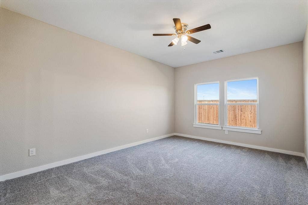 Recessed ceiling with an attached ceiling fan, dual windows, and carpeted flooring