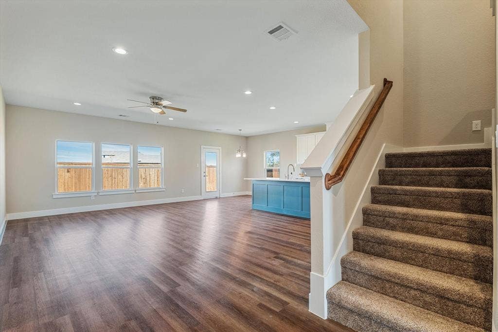 Spacious living area featuring wood-finish flooring, recessed lighting, and a ceiling fan