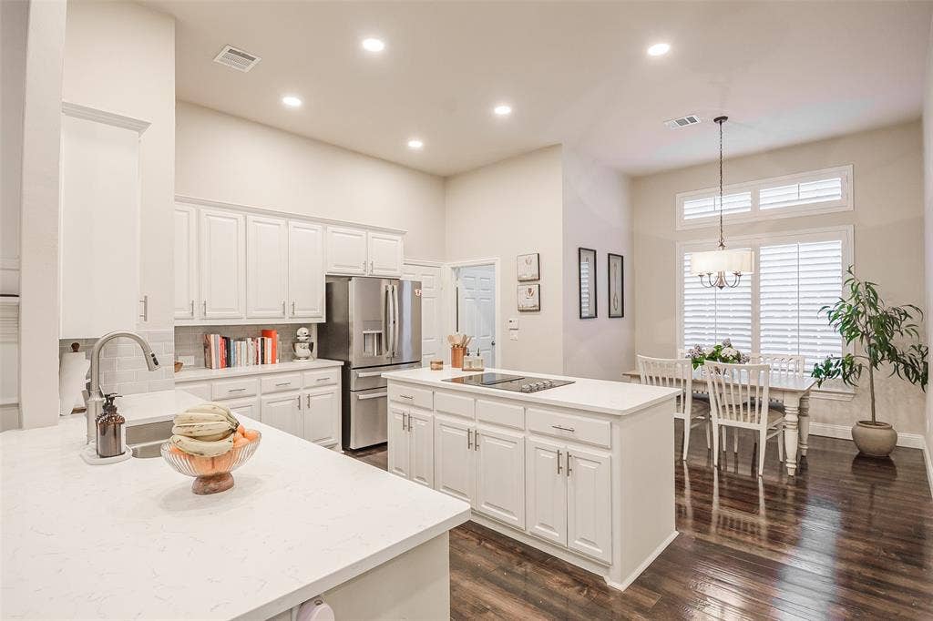 5925 Westmont Drive, Plano, TX 75093 Kitchen with white cabinetry, stainless steel appliances, and a central island with a cooktop