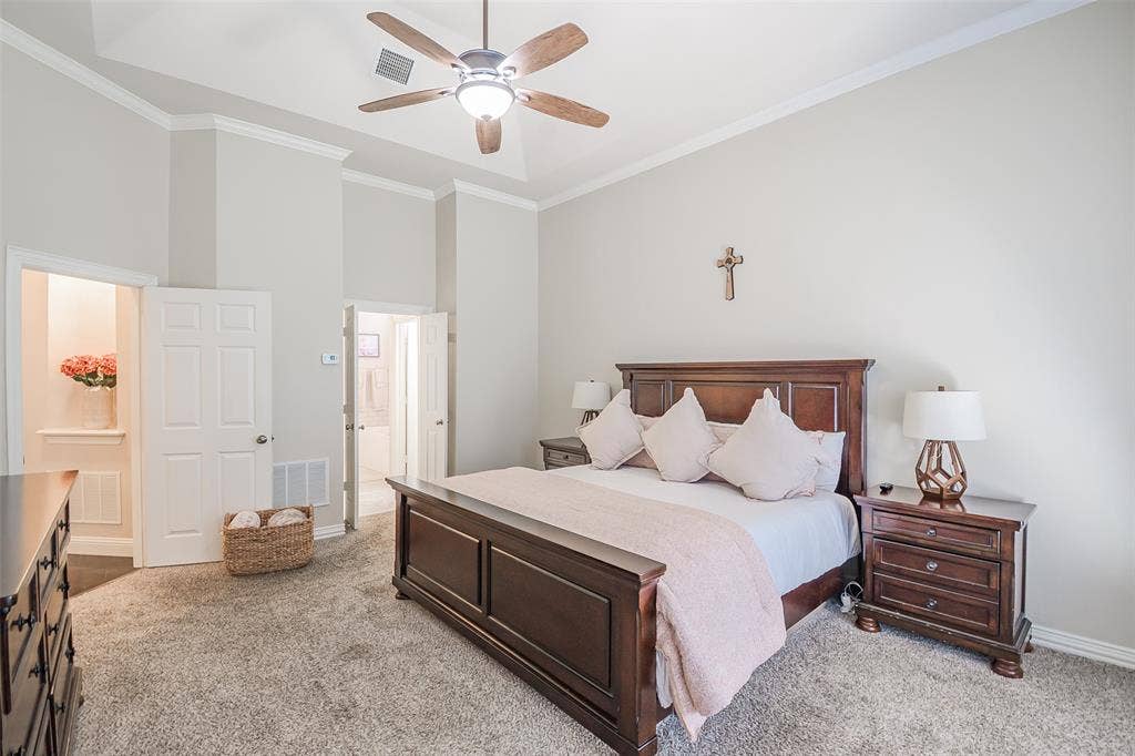 5925 Westmont Drive, Plano, TX 75093 Vaulted ceiling with crown molding, ceiling fan with integrated lighting, carpeted flooring, and a six-panel door