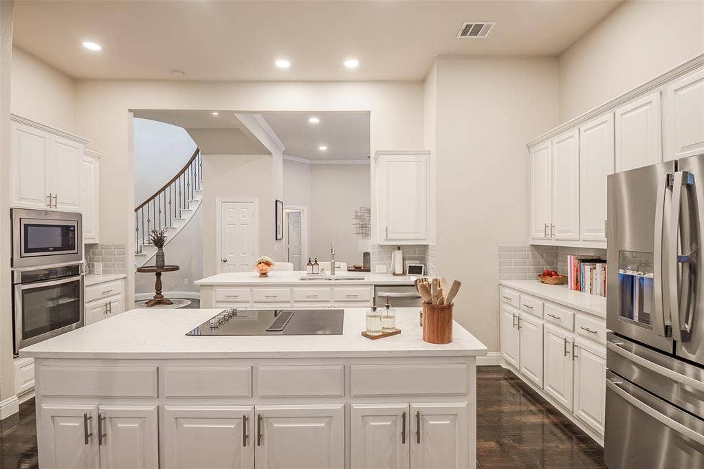5925 Westmont Drive, Plano, TX 75093 Kitchen featuring white cabinetry, light countertops, stainless steel appliances, a built-in oven, and wood-finish flooring
