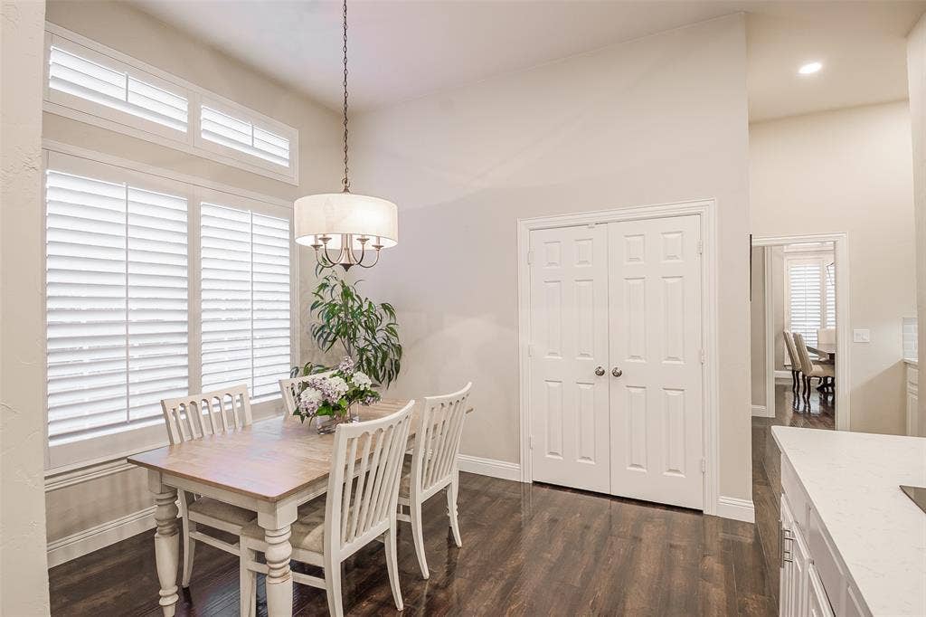 5925 Westmont Drive, Plano, TX 75093 Vaulted ceiling, wood-finish flooring, white plantation shutters, drum pendant light fixture, and two-panel bifold doors