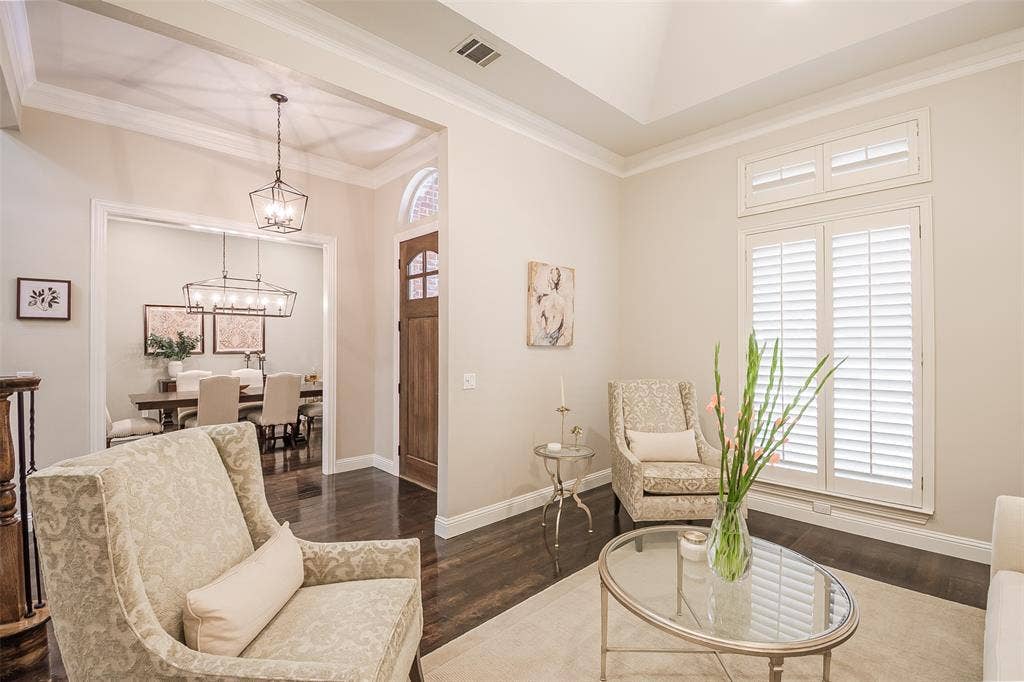 5925 Westmont Drive, Plano, TX 75093 Hardwood flooring throughout, tray ceiling, crown molding, plantation shutters, and a wood entry door with an arched transom