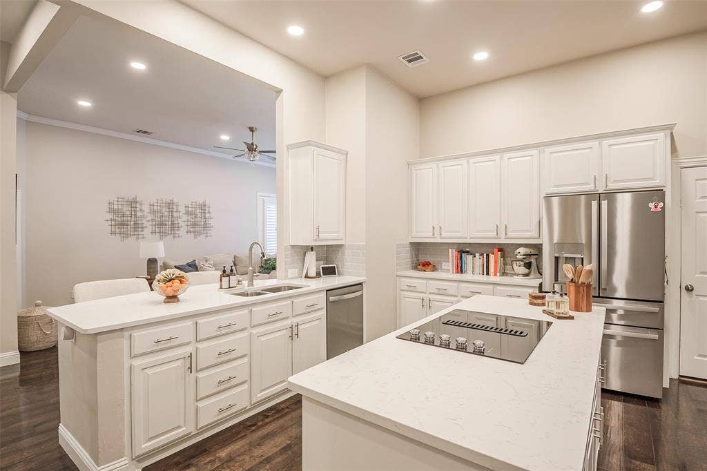5925 Westmont Drive, Plano, TX 75093 Kitchen featuring white cabinetry, stainless steel appliances, a center island with cooktop, quartz countertops, and dark wood-finish flooring
