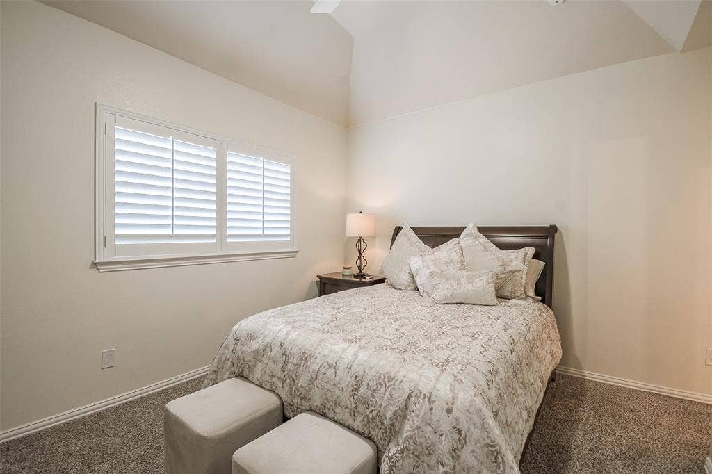 5925 Westmont Drive, Plano, TX 75093 Vaulted ceiling with a ceiling fan, dual windows featuring plantation shutters, and textured wall finish