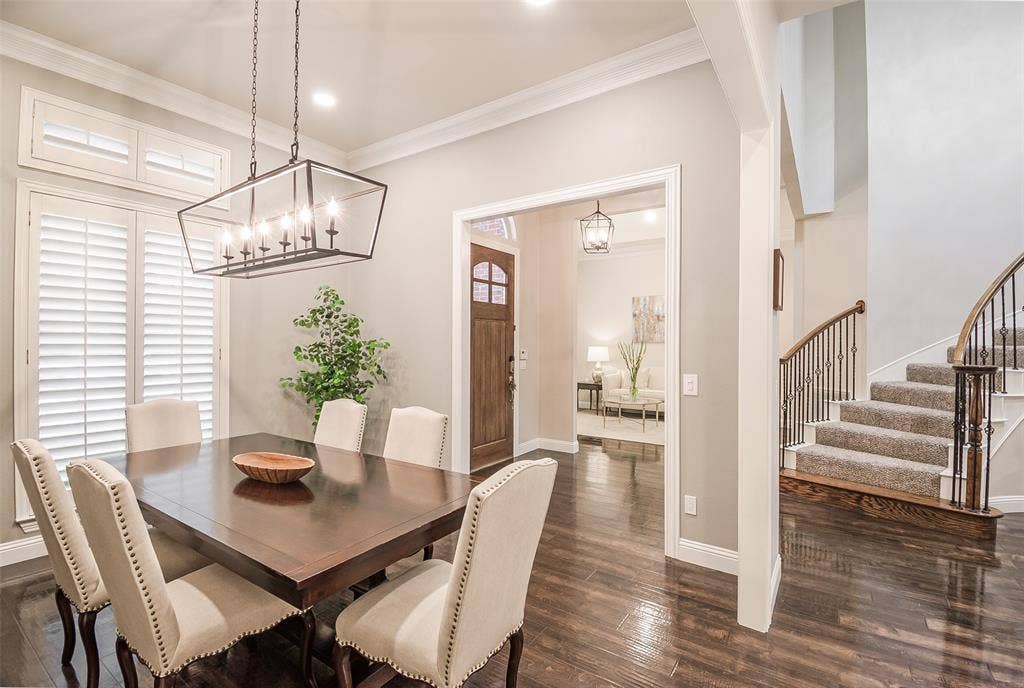 5925 Westmont Drive, Plano, TX 75093 Dining area featuring wood-finish flooring, a linear chandelier, and window shutters