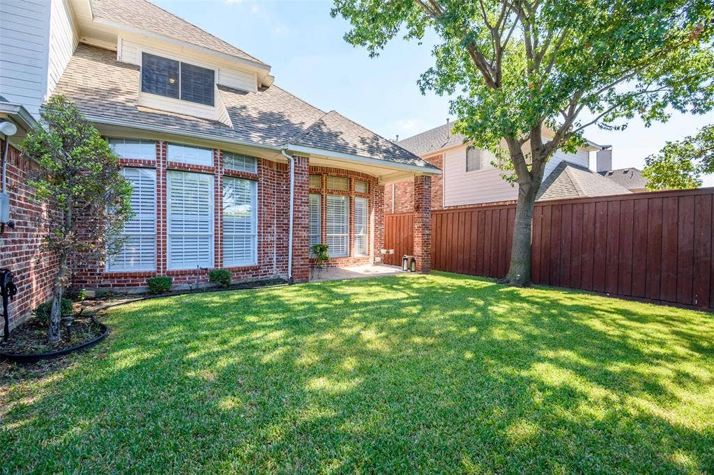 5925 Westmont Drive, Plano, TX 75093 Expansive grass yard with a wood fence and mature trees