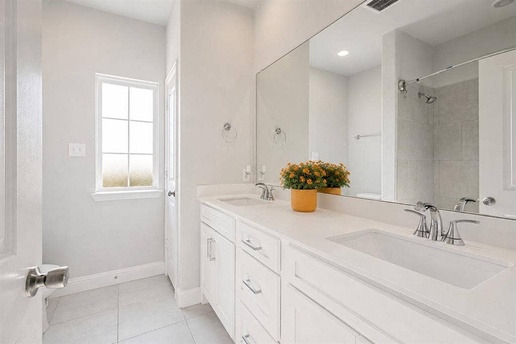 2902 Cremini Fls, Princeton, TX 75407 Dual vanity with integrated sinks, chrome fixtures, and a large wall-mounted mirror