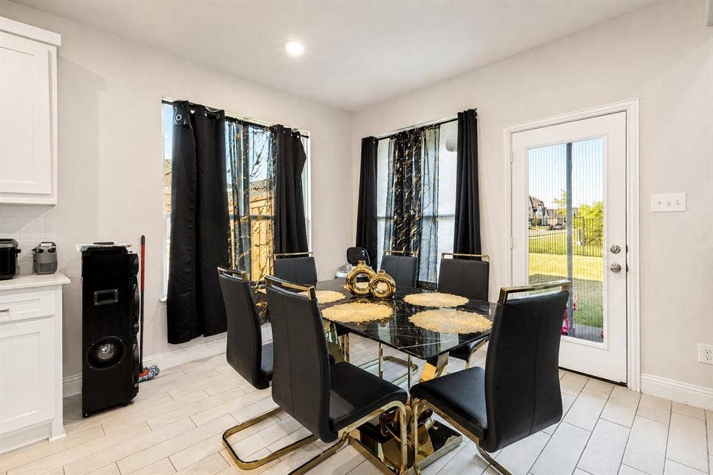 2902 Cremini Fls, Princeton, TX 75407 White shaker cabinetry with nickel hardware, subway tile backsplash, light-toned tile flooring, recessed ceiling lighting, and a full-light rear door