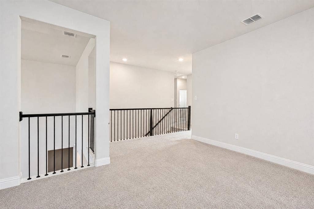 2902 Cremini Fls, Princeton, TX 75407 Carpeted upper level with recessed lighting, white walls, and black metal railings
