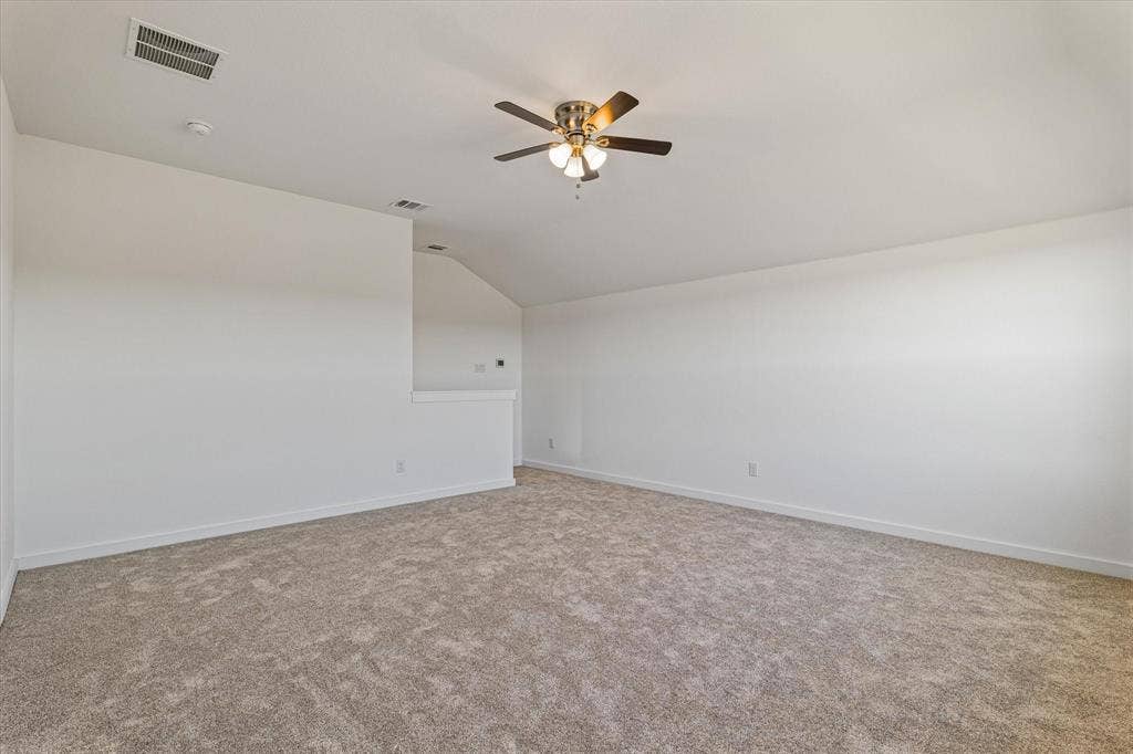 Vaulted ceiling with a ceiling fan, neutral carpet flooring, and white painted walls